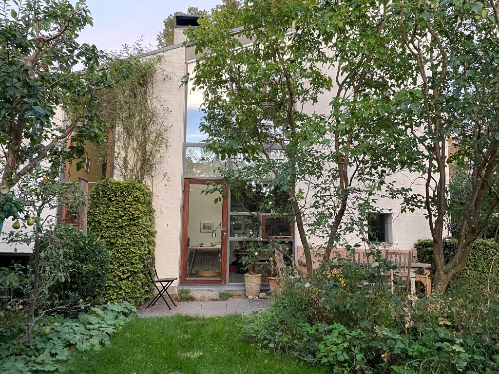 Tilbygning med glasparti set fra haven